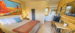 a bedroom with a bed and a wooden wall at Hózhó King Mokee Shared Kitchen, Pets Ok #2 in Bluff