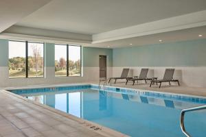 a large swimming pool with chairs in a building at Courtyard by Marriott Madison in Madison