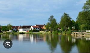 a view of a river with houses and trees at Maison du Gué 2 chambres in Gurgy