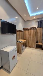 a room with a tv on the wall and a refrigerator at شقق الدار in Jeddah