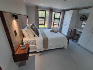 a bedroom with a large bed with a wooden headboard at White Sparrow Villa in Marloth Park +44 photos