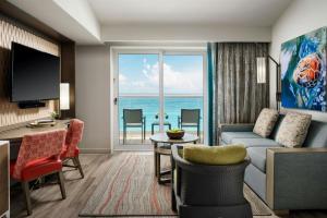 a living room with a couch and a room with a view of the ocean at The Westin Cancun Resort & Spa in Cancún
