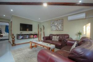 a living room with leather couches and a coffee table at White Sparrow Villa in Marloth Park