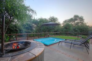 a patio with a fire pit and an umbrella at White Sparrow Villa in Marloth Park