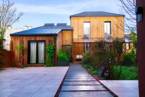 a wooden house with a walkway in front of it at Chalet urbain-150m2 jardin privatif-15mn de Paris in Le Bourget