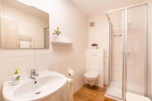 a white bathroom with a sink and a shower at Pension Buchfink in Ueckeritz +35 photos