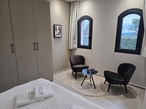 a bedroom with a bed and two chairs and a table at Suite Sieste en Provence in Entrecasteaux