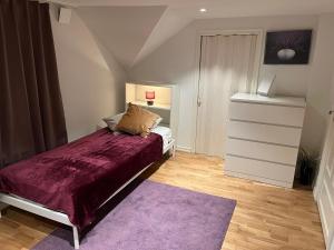 a bedroom with a bed and a purple rug at Sahlin - Kattarp in Kattarp
