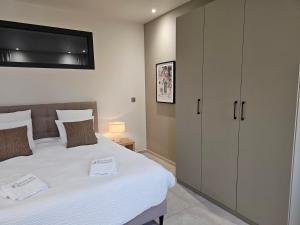 a bedroom with a large white bed with a cabinet at Suite Sieste en Provence in Entrecasteaux