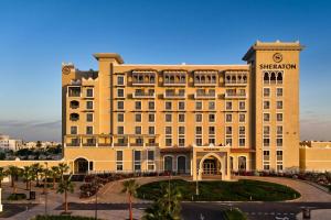 a large tan building with a clock on it at Sheraton Nouakchott Hotel in Nouakchott