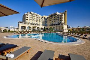 a hotel with a large swimming pool in front of a building at Sheraton Nouakchott Hotel in Nouakchott