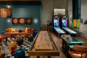 a room with two arcade games and a table at Moxy NYC Downtown in New York
