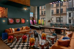 a living room with couches and a ping pong table at Moxy NYC Downtown in New York