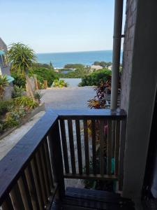 a wooden bench on a porch with a view of the ocean at Ocean rush barracuda in Zinkwazi Beach