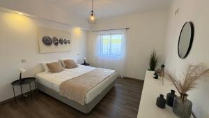 a white bedroom with a bed and a mirror at Monte Rio House in Luz +51 photos