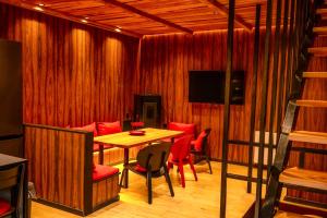 a dining room with a table and red chairs at Chalet urbain-150m2 jardin privatif-15mn de Paris in Le Bourget