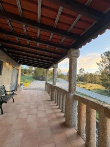 a porch with a wooden roof and a bench at Refúgio da Serra - Cottage House in Fornos de Algodres