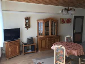 a living room with a tv and a wooden cabinet at PBJ Apartman in Pilisborosjenő