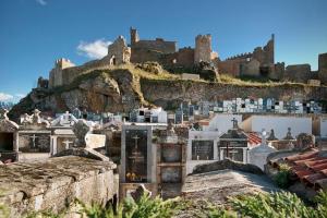 a castle on top of a hill with buildings at Ruralis Altozano in Montánchez