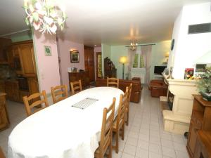 uma sala de jantar com uma mesa branca e cadeiras em Holiday home in Denneville near the beach em Denneville