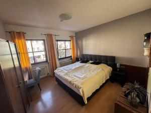 a bedroom with a bed and a desk and two windows at Hotel Zunftstube in Saarburg