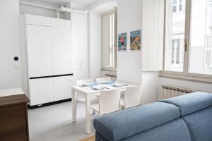 a living room with a white table and chairs at Bilocale in centro a 1 minuto da Piazza Unità in Trieste