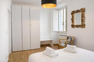 a white room with a table and a mirror at Bilocale in centro a 1 minuto da Piazza Unità in Trieste