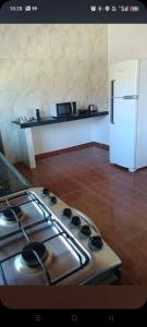 a kitchen with a stove and a white refrigerator at Pousada e Hostel Campo in Vespasiano