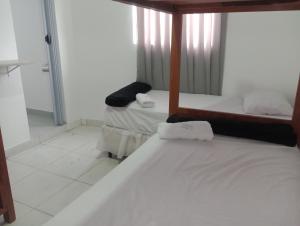 a room with two beds and a mirror in it at Pousada e Hostel Campo in Vespasiano +4 photos