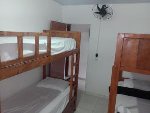 a room with two bunk beds and a clock on the wall at Pousada e Hostel Campo in Vespasiano