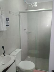 a bathroom with a shower and a toilet and a sink at Pousada e Hostel Campo in Vespasiano
