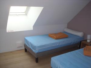 a attic room with two beds and a window at L 'Escale Morvandelle in Saint-Brisson