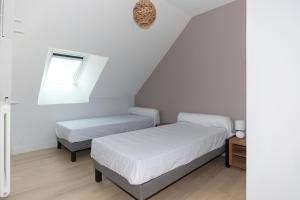 a bedroom with two beds and a window at L 'Escale Morvandelle in Saint-Brisson