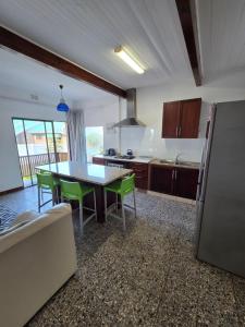 a kitchen with a table and green chairs in it at Ocean Rush in Zinkwazi Beach