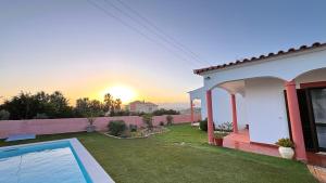 a villa with a swimming pool and a house at Monte Rio House in Luz