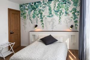 a bedroom with a bed with a flower mural on the wall at La Citadine in Neufchâteau