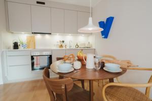 a kitchen with a wooden table with chairs and a dining room at Studio5 am Ringpark in Würzburg +21 photos