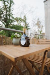 a bottle of wine sitting on a wooden table with glasses at Studio5 am Ringpark in Würzburg