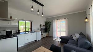 a living room with a blue couch and a kitchen at Monte Rio House in Luz