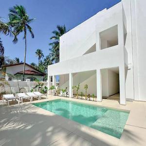 a white house with a swimming pool in front of it at Private Beach Front 2-Bedroom Apartment, Groundfloor in Kiwengwa +54 photos