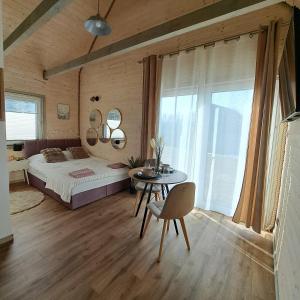 a bedroom with a bed and a table and window at Leśny Reset 2 in Grabowo