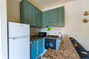 a kitchen with green cabinets and a white refrigerator at Binario 22 in San Gemini