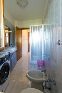 a bathroom with a toilet and a sink and a washing machine at Binario 22 in San Gemini