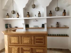 a room with a wooden table with vases on shelves at Hôtel Riad La Nouvelle Etoile - Agadir in Agadir