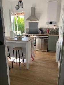 a kitchen with a white counter and a stool at Gîte le Taurion in Saint-Priest-Taurion