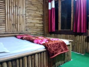 a bed with a blanket on top of it at Meghh Minar Homestay Sillery Gaon in Kalimpong