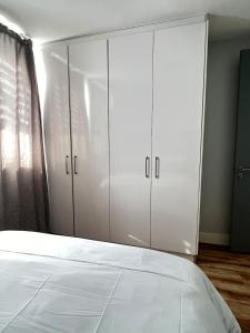 a bedroom with white cabinets and a bed at Finagaello 3 bedrooms-Self catering at 77 on Independence in Windhoek