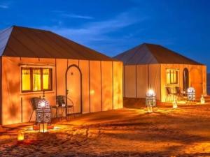 a large building with a table and chairs in it at Stellar Luxury Camp in Merzouga