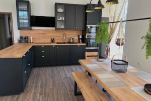 a kitchen with black cabinets and a wooden table at O Cantinho da Cotovia in Valpaços