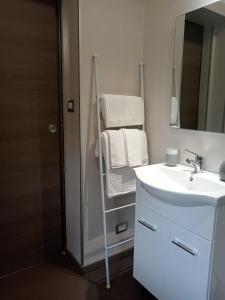 a bathroom with a sink and a towel rack at ATHENA Home Asti in Asti
